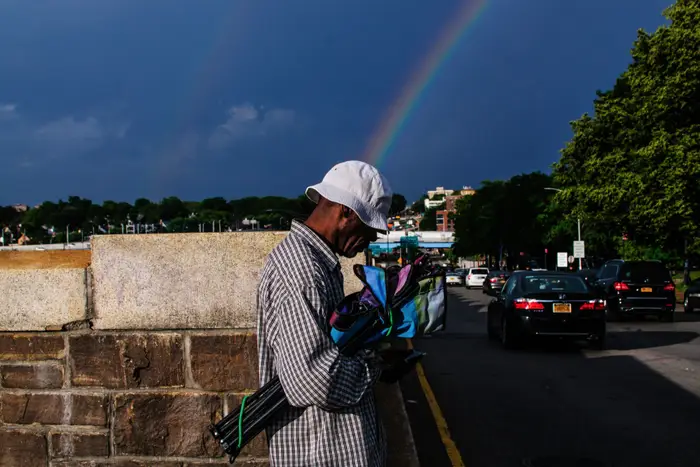 A photo of a man with a rainbow behind him